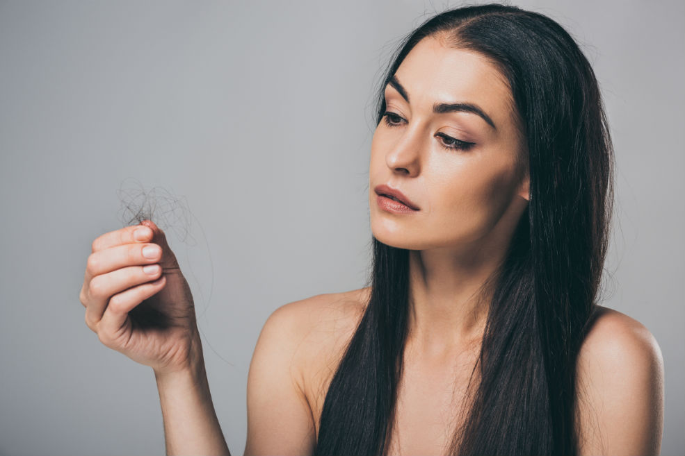 Mujer analizando caída de cabello: ¿posible alopecia frontal fibrosante?