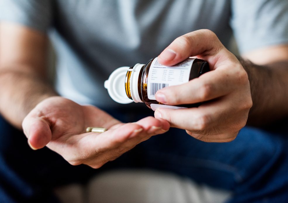 Hombre sujetando medicamentos  en la mano