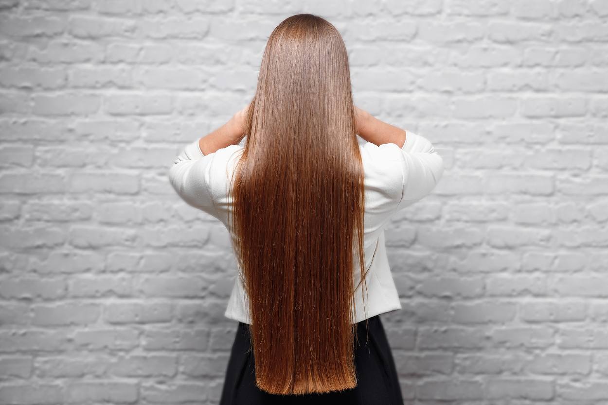 Mujer con pelo muy largo y liso, de espaldas