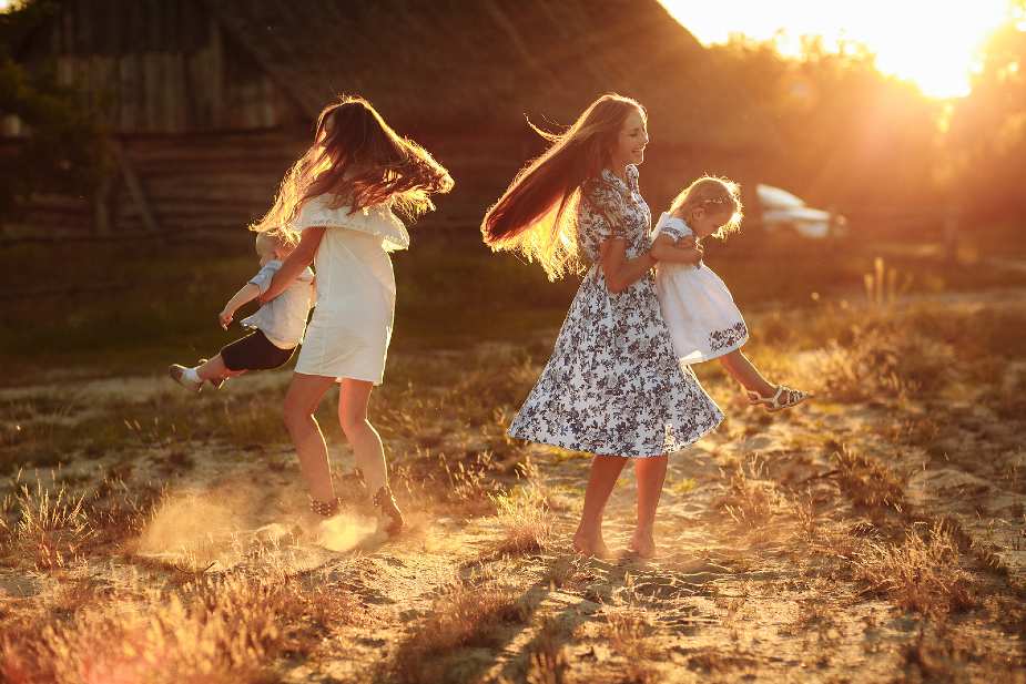 Mujeres jugando con niños al atardecer al aire libre