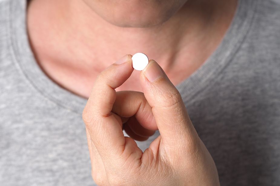 Hombre con un medicamento en la mano.