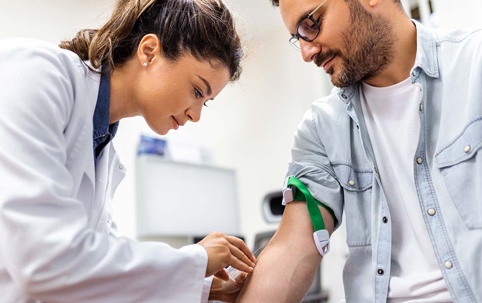 Especialista le toma sangre a un paciente de Elithair